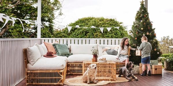 Christmas themed back porch with kids playing on an outdoor setting 