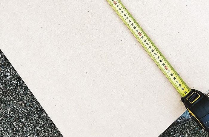 Measuring the length of MDF board using a measuring tape.