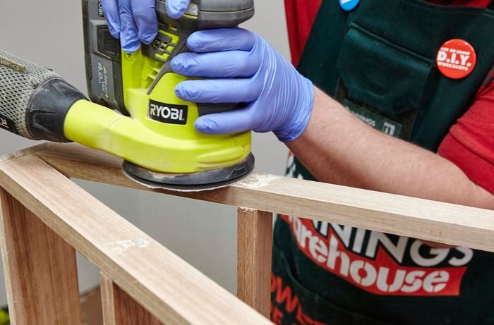 The joints of a shoe storage rack being sanded down
