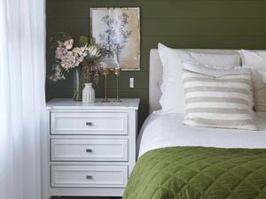 Organized and clean bedroom with bed, side table and decoration. 