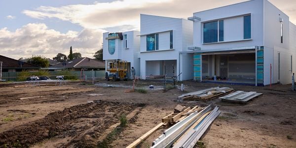 A half complete building on a clean jobsite with mud in the foreground.