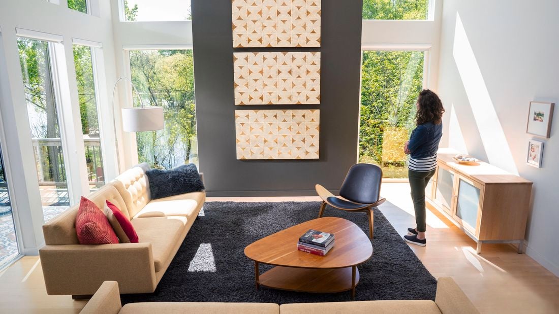 Person looking at wall prints hung on wall in a living room.