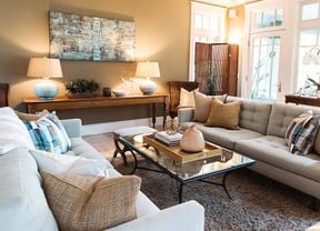 A living room with couches, cushions, a rug, a coffee table and LED lamps.