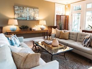 A living room with couches, cushions, a rug, a coffee table and LED lamps.