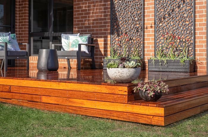 Decking outside of a house with 2 x garden panels, chairs and plants