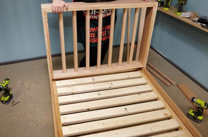 Person attaching bedhead to bed frame