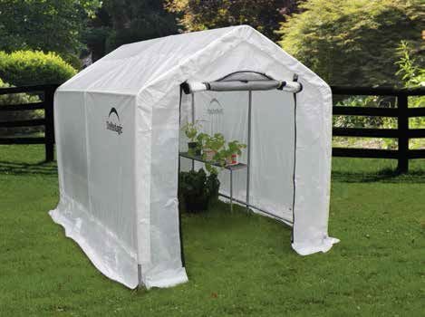 Potted plants inside a portable greenhouse with shelves