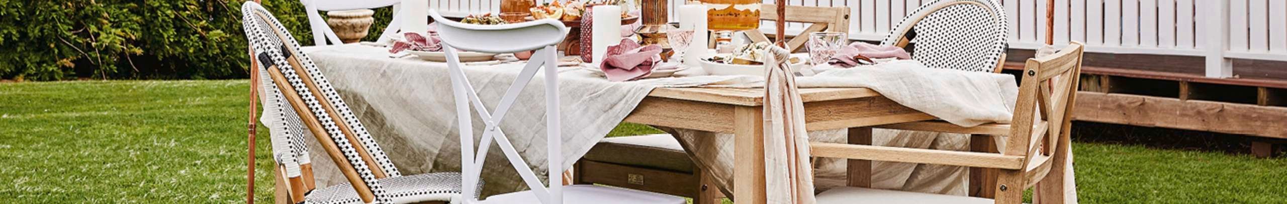 Outdoor area with dining table set with dogs lying in frame