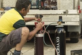 Person adjusting gas from large canister