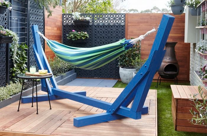 Outdoor decking area with blue and green hammock on it.