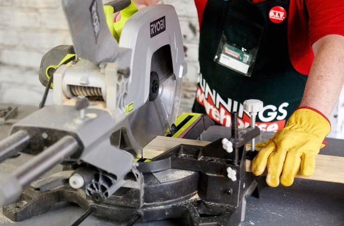 A mitre saw being used to cut a length of timber for a bar counter