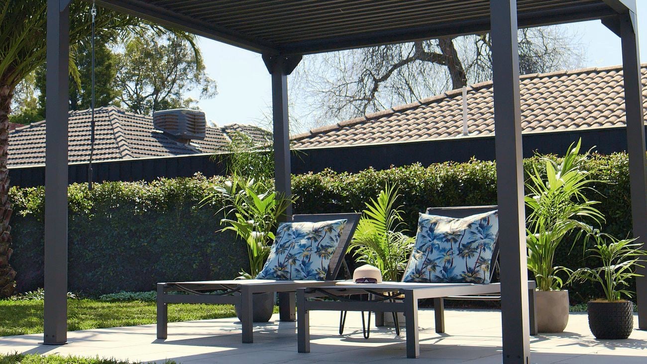 Two outdoor deck chairs with brightly coloured cushions.