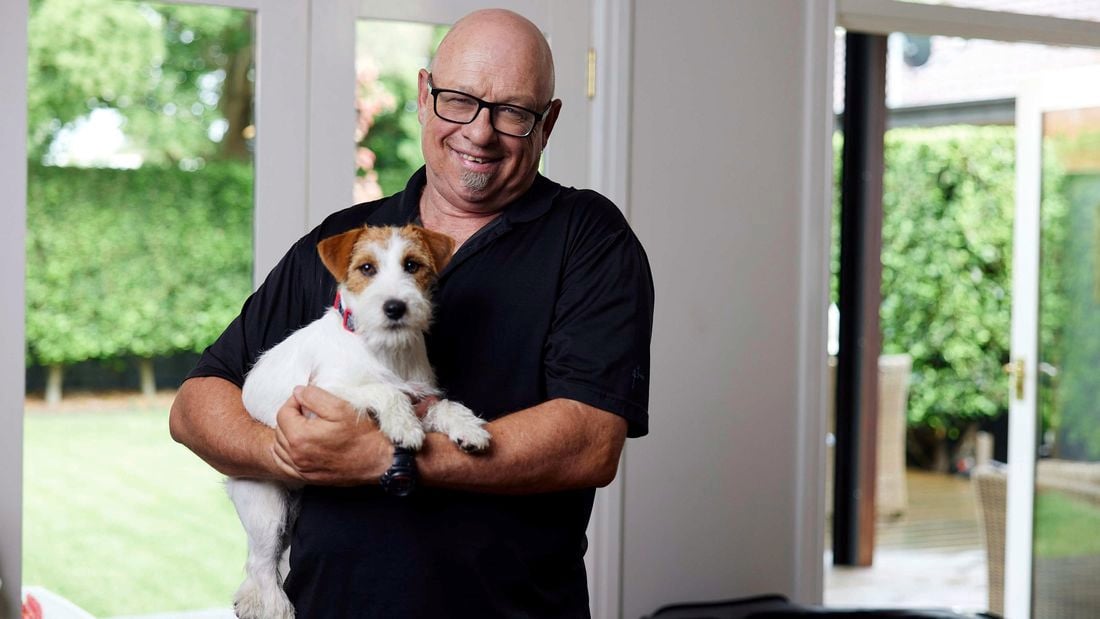 A person holing his puppy.