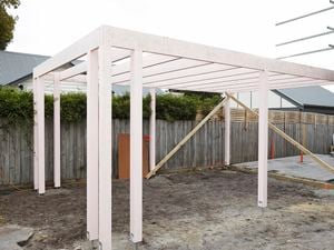Timber frame of a carport painted white
