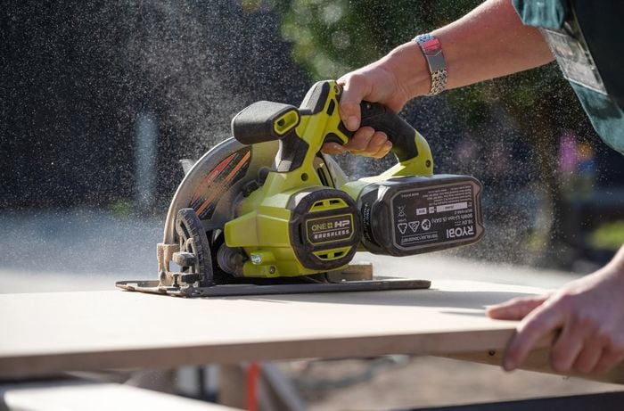 A person cutting the the bench seat to size using a jigsaw.