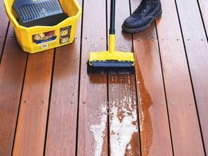 Man washing his concrete floor using a high pressure water cleaner