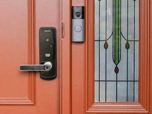 Smart door lock and Ring video doorbell installed on a red front door with decorative glass panel