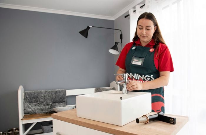 Bunnings team member adjusting the fit of the tap on the sink