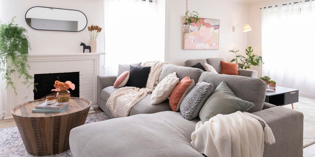 Living room with grey couches, timber coffee table and fireplace.