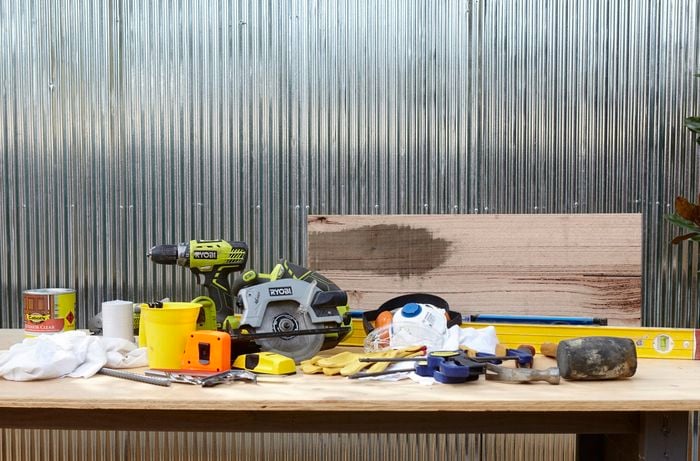 Various tools and materials needed to prepare and install timber wall shelves.
