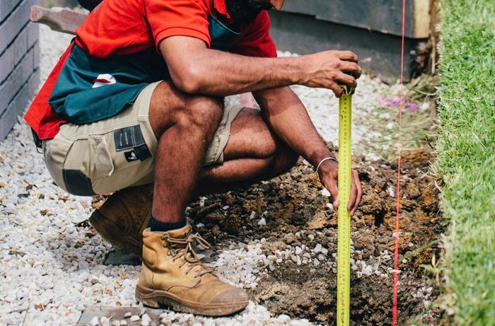 Tape measure and string being used to mark out the position of a retaining wall