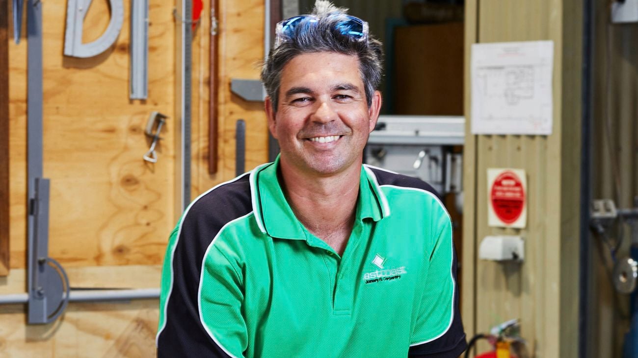 Close up image of a Builder Kieren Chapman in a workshop wearing a hi-vis shirt