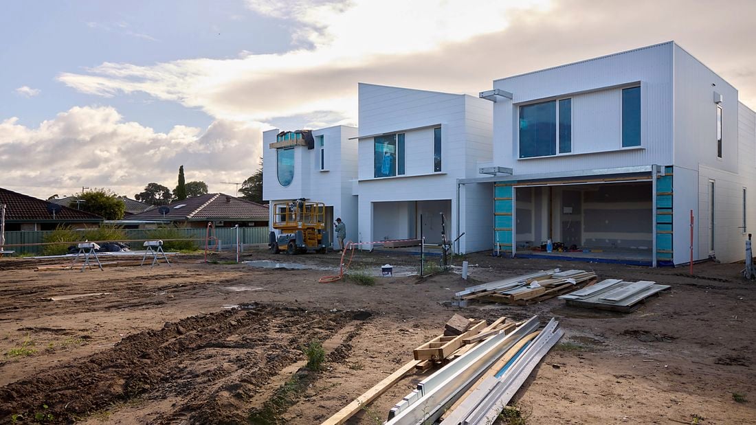 A half complete building on a clean jobsite with mud in the foreground.