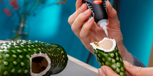 Applying adhesive to repair a broken ceramic decorative object