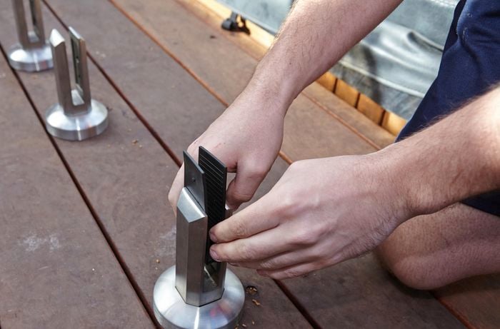 Person inserting metal plates and grips into mini post.