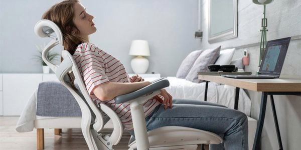 Person relaxed and leaning back on a SIHOO chair in a bedroom