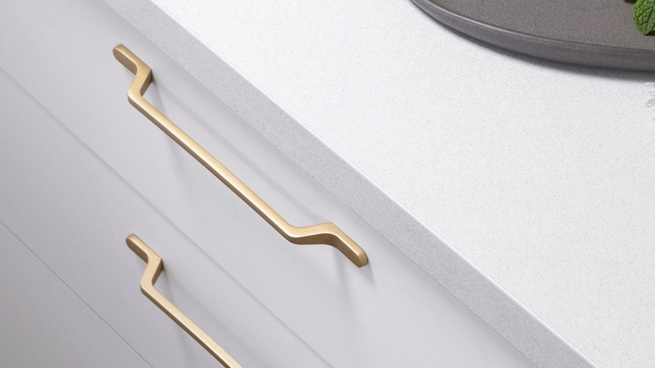 Close up of kitchen handles in brushed-brass with lemon on countertop
