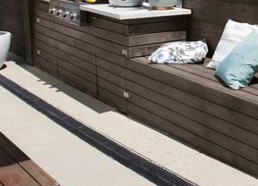 Seating in an outdoor setting cut out of lawn slope with throw cushions