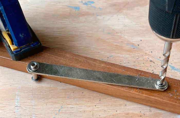 Close up of a drill removing the rivet in a length of wood