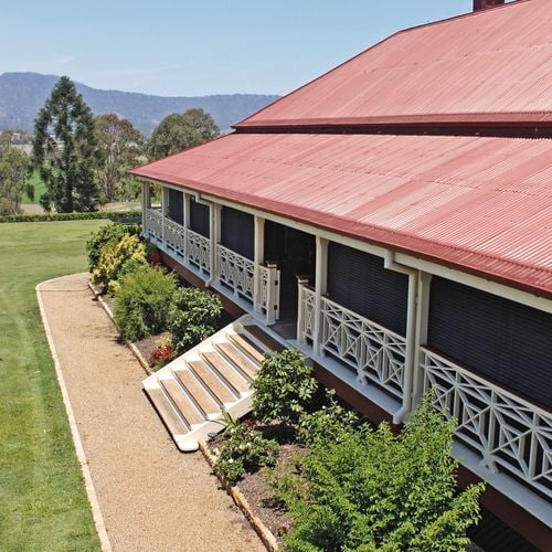 An image of a roof with an installed gutter mesh and a well-maintained garden.