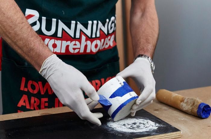 A person removing tape from a PVC pipe
