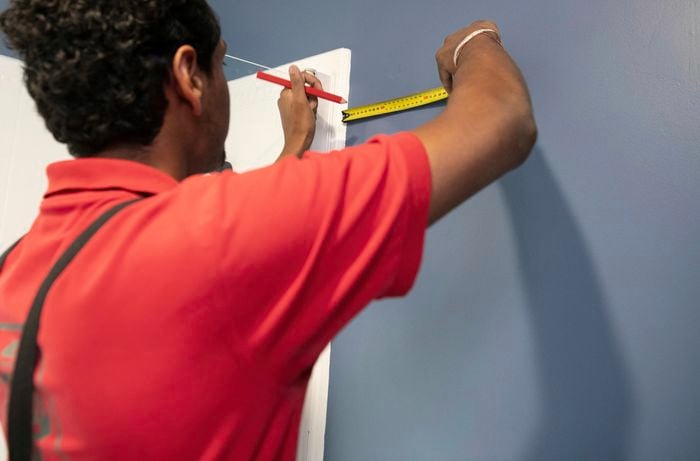 A Bunnings team member measuring space from a wall feature