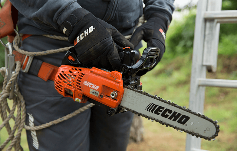 A man in protective clothing wielding a chainsaw