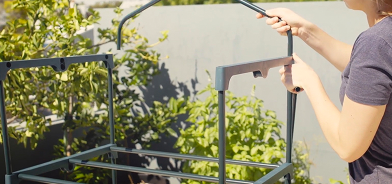 Person assembling frame of small greenhouse