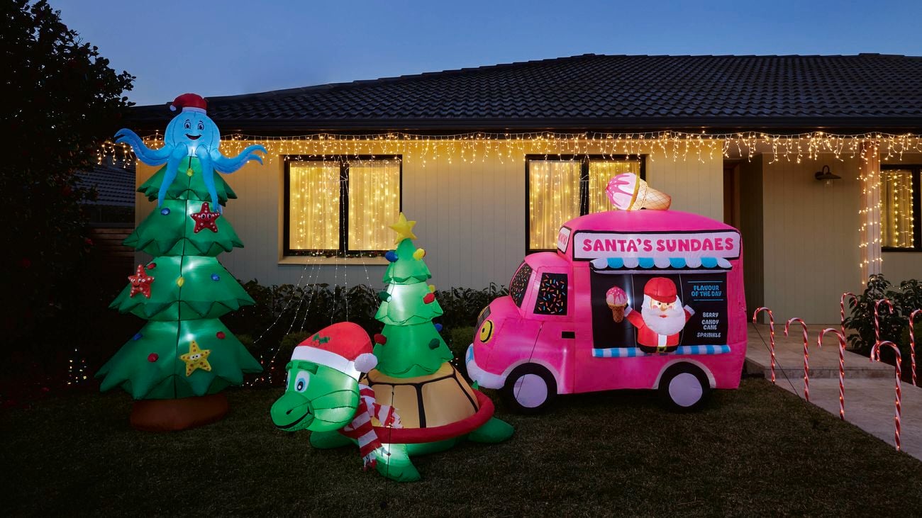 house decorated with Christmas lights and inflatables at the front of the house