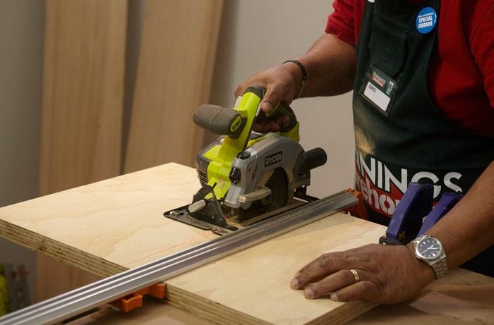 Person using circular saw to cut piece of ply wood.