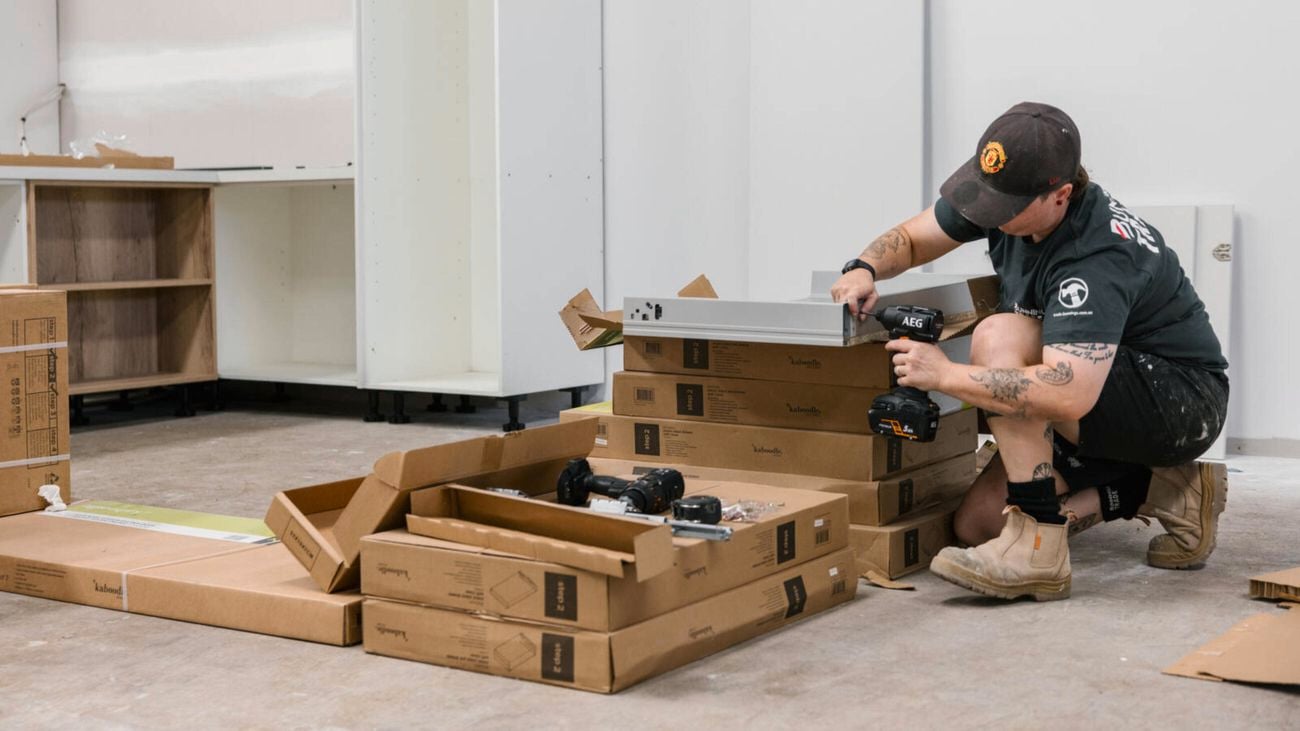 Kara Shipp uses the impact driver from the AEG combo kit on a work site