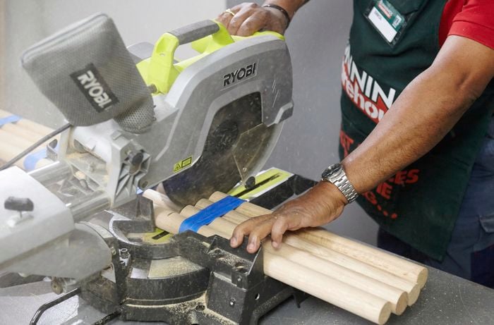A mitre saw being used to cut several bar stool legs at once