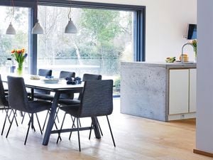 Modern kitchen with pendant lights, table setting and island bench