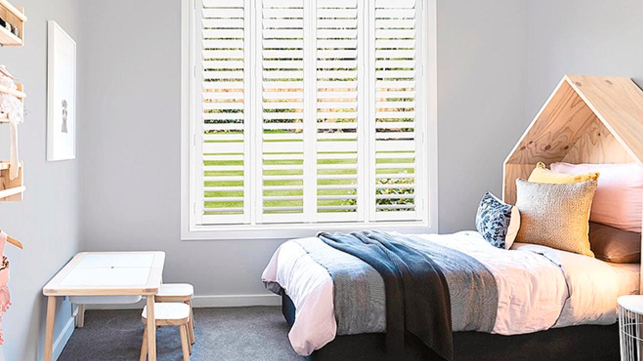 A children's bedroom with plantation shutters in white.