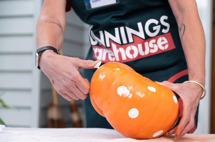 Bunnings team member painting thumbprints.