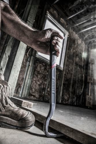 A tradesman using a crowbar