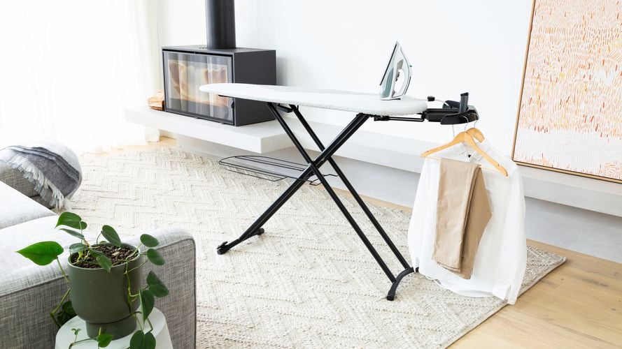 Hills XL Ironing Board with shirts and iron in living room.