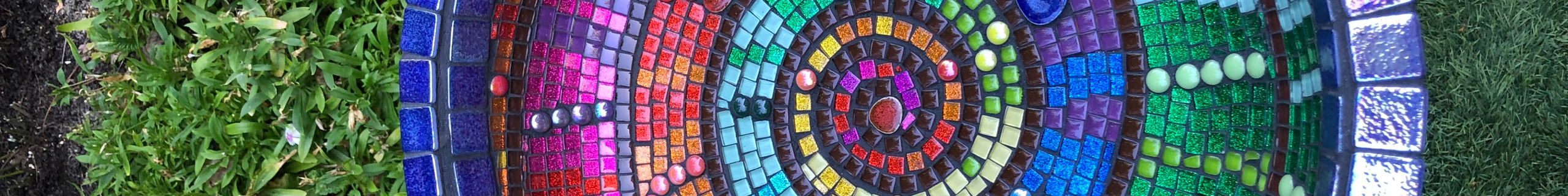 Circular art made with multicoloured tiles in the garden.