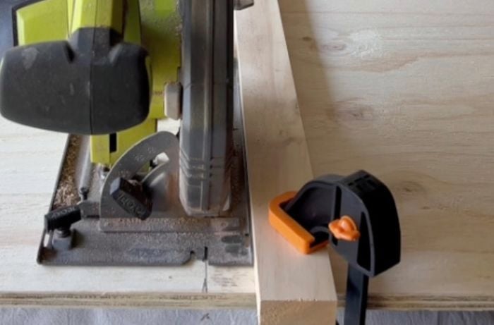 Circular saw cutting through piece of plywood on benchtop