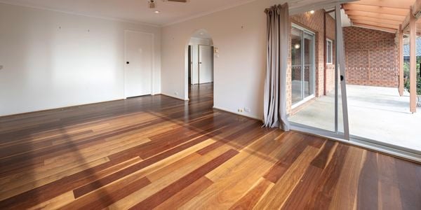 Empty room with wooden floorboards and fan on the ceiling